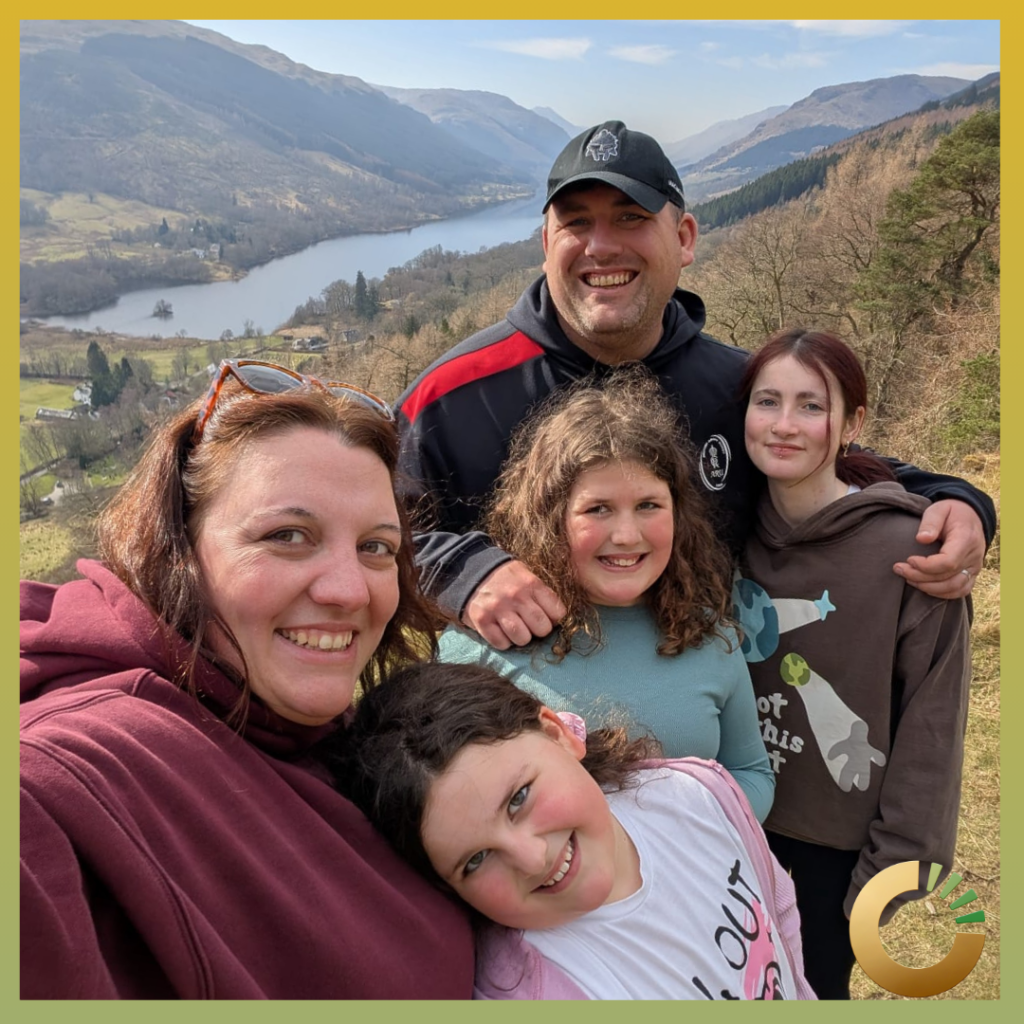 a photograph of a Forces family of 5 people standing in front of a lake on a respite break